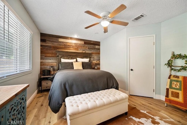 7635 Sombrilla Ave, Atascadero, CA 93422 - bedroom featuring wooden walls, a textured ceiling, light wood-type flooring, and ceiling fan