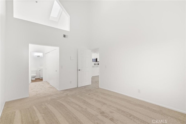 20331 Bluffside Unit A408, Huntington Beach, CA 92646 - unfurnished living room featuring a high ceiling and light colored carpet