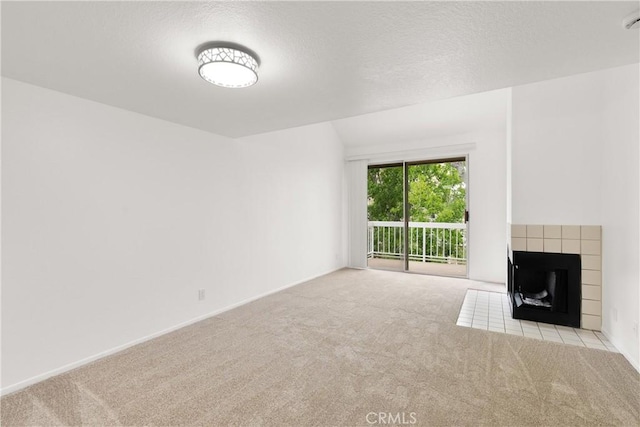 20331 Bluffside Unit A408, Huntington Beach, CA 92646 - unfurnished living room with carpet, a tiled fireplace, and a textured ceiling