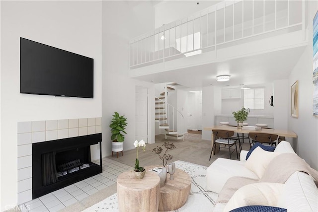 20331 Bluffside Unit A408, Huntington Beach, CA 92646 - living room with stairway, a towering ceiling, and a fireplace