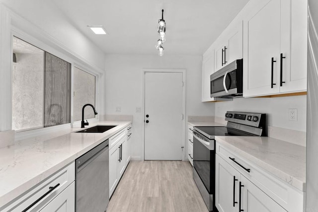 155 Countrywood Ln, Encinitas, CA 92024 - kitchen with appliances with stainless steel finishes, light wood-style flooring, light stone countertops, and white cabinets