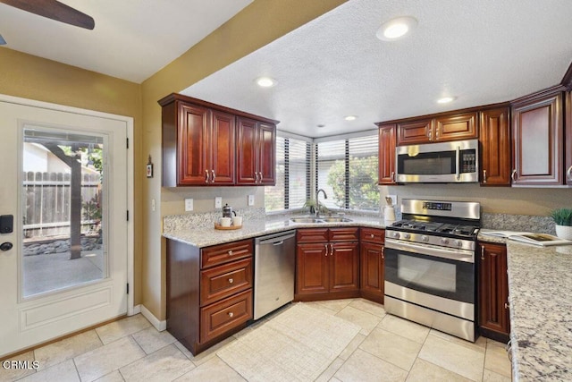 116 La Veta Dr, Camarillo, CA 93012 - kitchen with appliances with stainless steel finishes, recessed lighting, light tile patterned flooring, light stone countertops, and reddish brown cabinets
