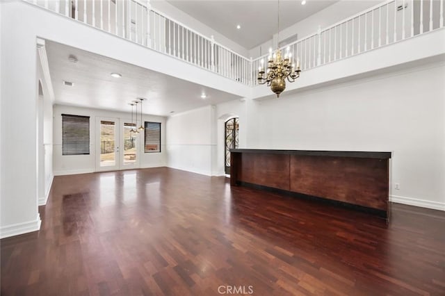 5 Vista Loreta, Lake Elsinore, CA 92532 - unfurnished living room featuring a chandelier, arched walkways, wood finished floors, a high ceiling, and french doors