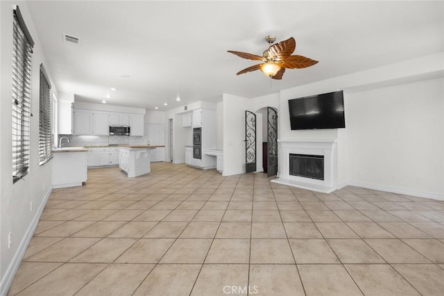 5 Vista Loreta, Lake Elsinore, CA 92532 - unfurnished living room featuring recessed lighting, ceiling fan, a glass covered fireplace, and light tile patterned floors