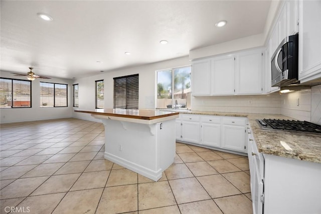 5 Vista Loreta, Lake Elsinore, CA 92532 - kitchen with stainless steel appliances, light tile patterned floors, tasteful backsplash, white cabinets, and recessed lighting