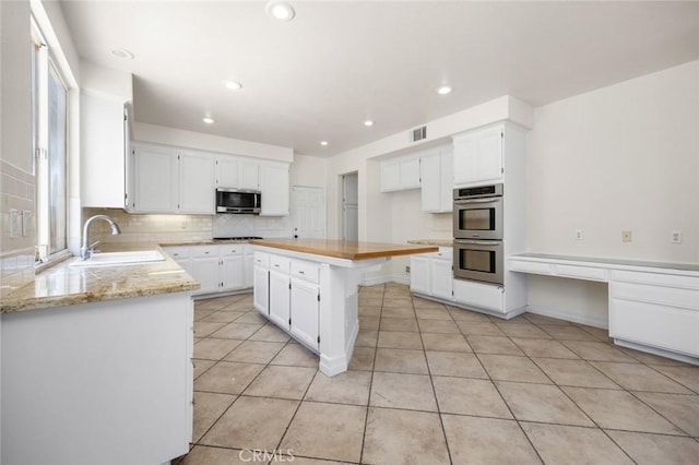 5 Vista Loreta, Lake Elsinore, CA 92532 - kitchen featuring stainless steel appliances, white cabinets, light tile patterned flooring, decorative backsplash, and recessed lighting