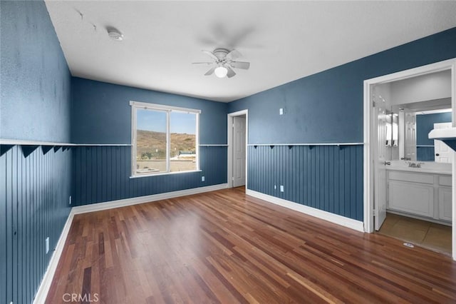 5 Vista Loreta, Lake Elsinore, CA 92532 - unfurnished bedroom featuring a wainscoted wall, wood finished floors, ensuite bath, and ceiling fan