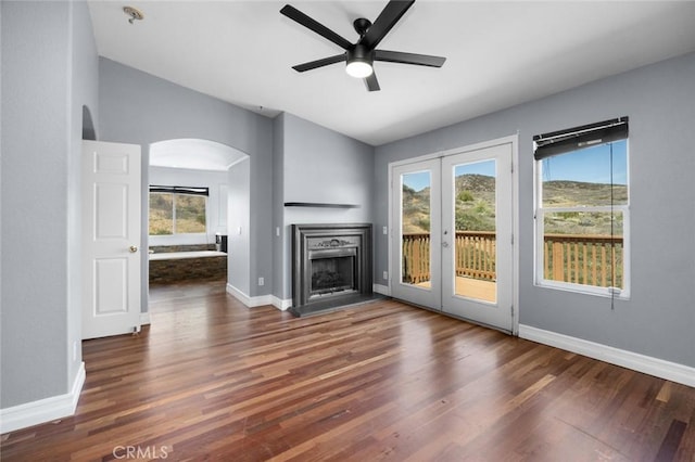 5 Vista Loreta, Lake Elsinore, CA 92532 - unfurnished living room featuring arched walkways, ceiling fan, wood finished floors, vaulted ceiling, and a fireplace