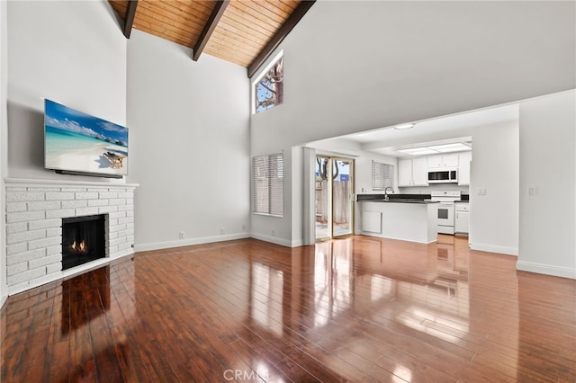 12698 Shearer Ln, Garden Grove, CA 92843 - unfurnished living room featuring high vaulted ceiling, a wood ceiling with exposed beams, light wood-type flooring, and a brick fireplace