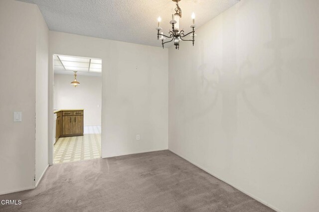 13208 Village 13 Unit 13, Camarillo, CA 93012 - carpeted empty room with a chandelier and a textured ceiling