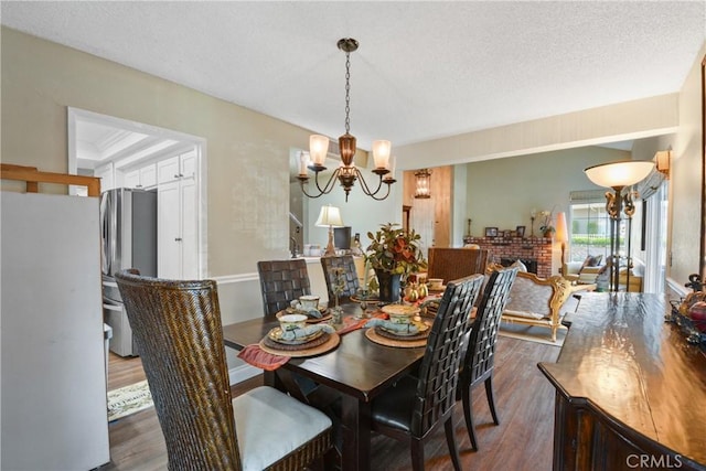 1943 Horseshoe Cir, Placentia, CA 92870 - dining area with dark wood-style floors, a chandelier, a textured ceiling, and a fireplace