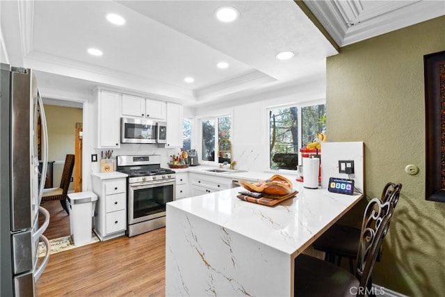 1943 Horseshoe Cir, Placentia, CA 92870 - kitchen with stainless steel appliances, a peninsula, light wood-type flooring, ornamental molding, and a textured wall