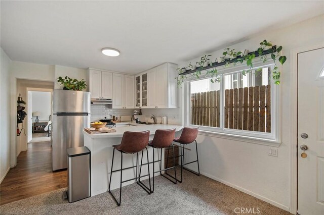 1413 Avenida De La Estrella, San Clemente, CA 92672 - kitchen featuring freestanding refrigerator, glass insert cabinets, a kitchen bar, white cabinetry, and light countertops