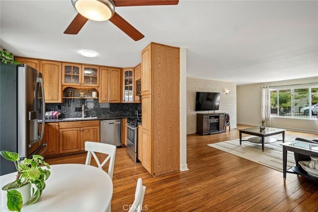 1413 Avenida De La Estrella, San Clemente, CA 92672 - kitchen with stainless steel appliances, ceiling fan, tasteful backsplash, wood finished floors, and glass insert cabinets
