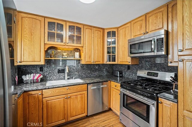 1413 Avenida De La Estrella, San Clemente, CA 92672 - kitchen with stainless steel appliances, backsplash, light wood finished floors, glass insert cabinets, and dark stone countertops