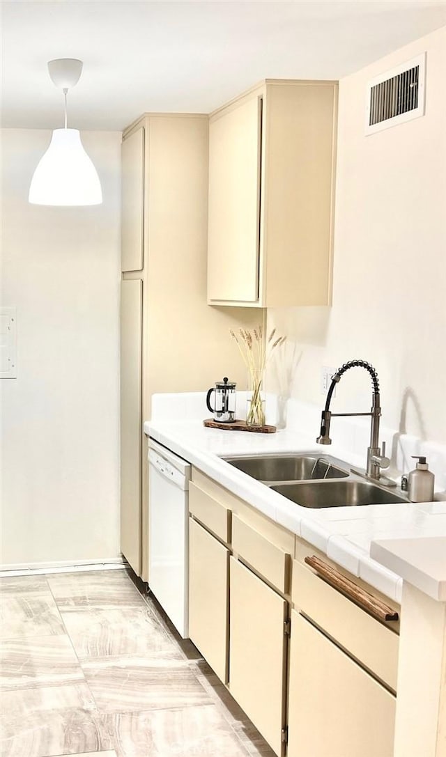 23515 Lyons Ave Unit 232, Valencia, CA 91355 - kitchen with white dishwasher, cream cabinets, light countertops, and hanging light fixtures