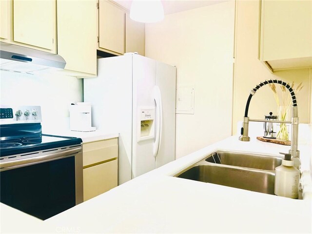 23515 Lyons Ave Unit 232, Valencia, CA 91355 - kitchen with stainless steel electric stove, range hood, white refrigerator with ice dispenser, light countertops, and cream cabinetry