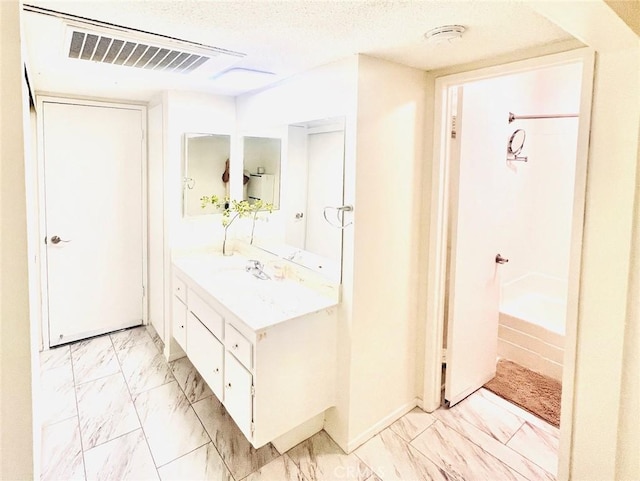 23515 Lyons Ave Unit 232, Valencia, CA 91355 - full bathroom featuring marble look tile flooring, vanity, and a textured ceiling
