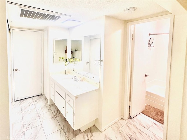 23515 Lyons Ave Unit 232, Valencia, CA 91355 - full bath featuring vanity, marble look tile flooring, and a textured ceiling