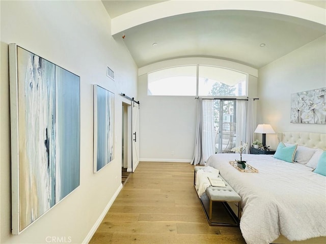 4723 La Villa Marina Unit F, Marina Del Rey, CA 90292 - bedroom featuring light wood-style flooring, arched walkways, vaulted ceiling, and a barn door