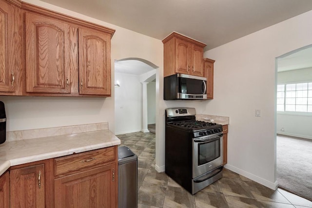 522 Garfield St, Oceanside, CA 92054 - kitchen with stainless steel appliances, arched walkways, brown cabinetry, and light countertops