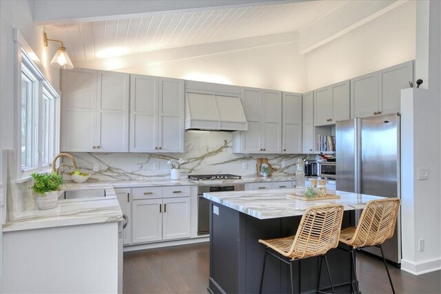 2103 Benson Ave, Cambria, CA 93428 - kitchen featuring premium range hood, lofted ceiling, backsplash, dark wood-style flooring, and appliances with stainless steel finishes