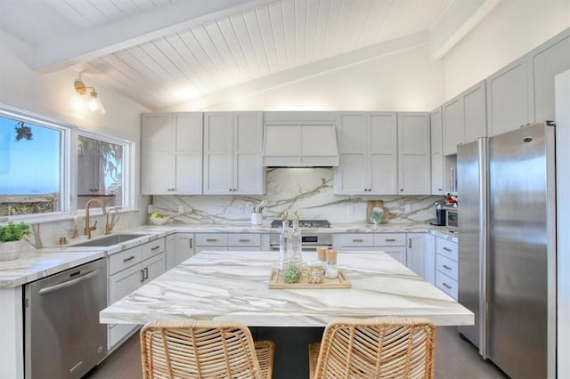 2103 Benson Ave, Cambria, CA 93428 - kitchen with stainless steel appliances, custom exhaust hood, tasteful backsplash, a kitchen bar, and light stone countertops