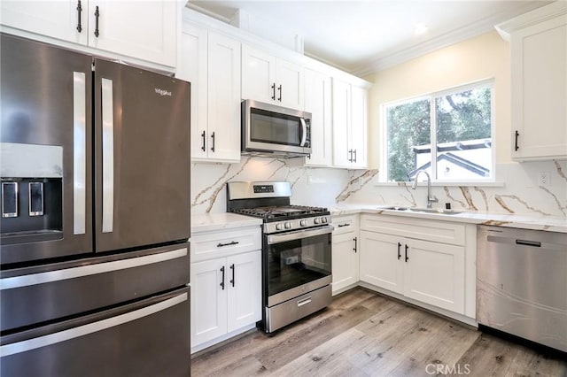 3264 E Holt Ave, West Covina, CA 91791 - kitchen with stainless steel appliances, ornamental molding, light wood-style floors, white cabinets, and light stone counters
