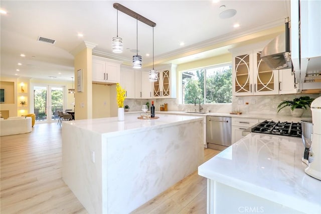 3264 E Holt Ave, West Covina, CA 91791 - kitchen with stainless steel dishwasher, island exhaust hood, light wood finished floors, glass insert cabinets, and decorative backsplash