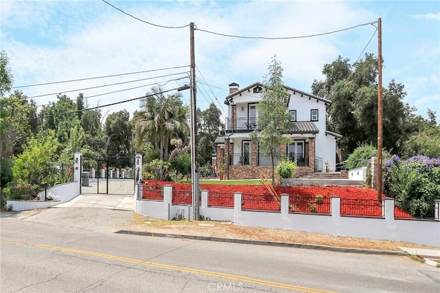 3264 E Holt Ave, West Covina, CA 91791 - view of front of home with a fenced front yard, a balcony, a gate, a chimney, and concrete driveway