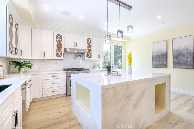 3264 E Holt Ave, West Covina, CA 91791 - kitchen with stainless steel appliances, backsplash, a kitchen island, light wood-type flooring, and crown molding