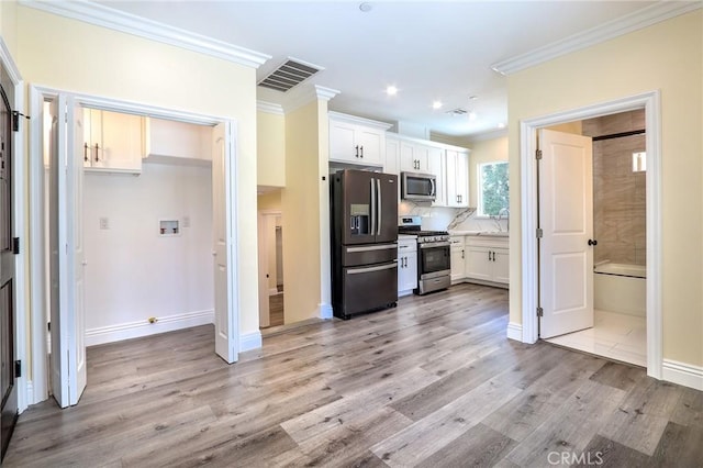 3264 E Holt Ave, West Covina, CA 91791 - kitchen with stainless steel appliances, ornamental molding, white cabinetry, light wood-type flooring, and recessed lighting