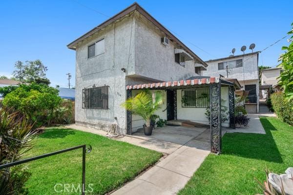 3014 E 3rd St, Los Angeles, CA 90033 - view of front of home featuring a front lawn and stucco siding