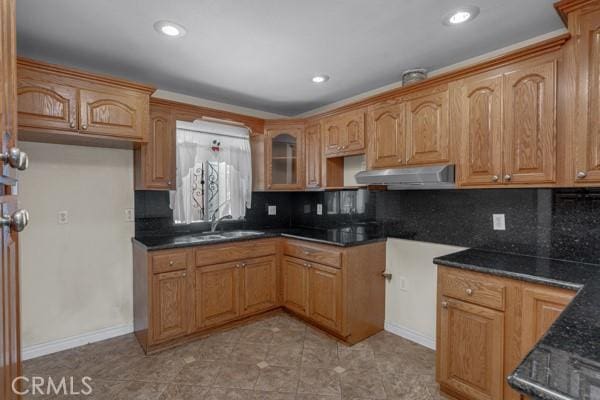 3014 E 3rd St, Los Angeles, CA 90033 - kitchen featuring range hood, tasteful backsplash, light tile patterned floors, recessed lighting, and glass insert cabinets