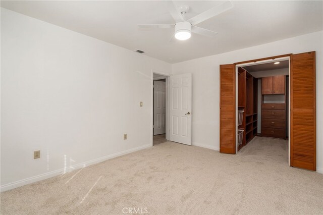 2041 Caballeros Rd, Norco, CA 92860 - unfurnished bedroom with light carpet, a walk in closet, a closet, and a ceiling fan