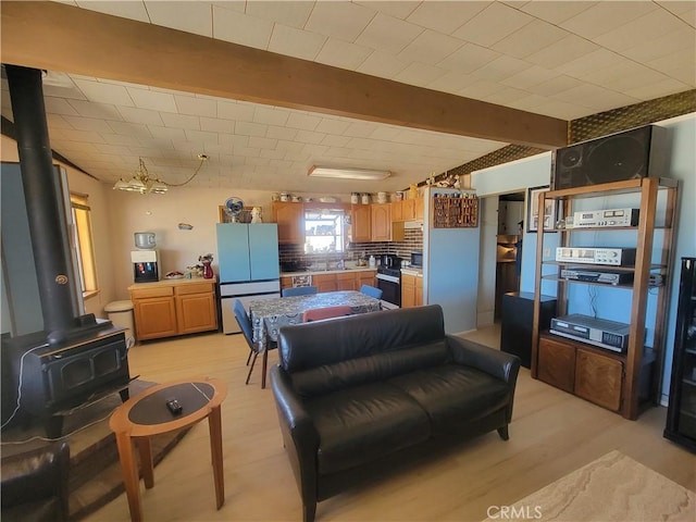 5566 Oleta Rd, Landers, CA 92285 - living area with light wood finished floors, a wood stove, and beamed ceiling