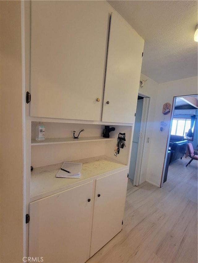 5566 Oleta Rd, Landers, CA 92285 - laundry room featuring light wood-type flooring and a textured ceiling