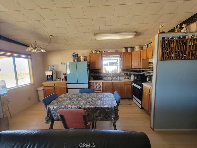 5566 Oleta Rd, Landers, CA 92285 - kitchen featuring freestanding refrigerator, stainless steel range with electric stovetop, a chandelier, light countertops, and tasteful backsplash