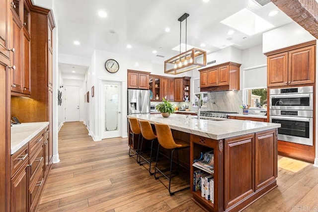 10166 Rancho Roble Rd, Escondido, CA 92026 - kitchen featuring stainless steel appliances, open shelves, a kitchen breakfast bar, light wood-style flooring, and recessed lighting