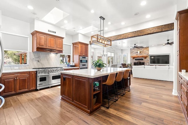 10166 Rancho Roble Rd, Escondido, CA 92026 - kitchen featuring double oven range, light wood-style flooring, open floor plan, a center island, and decorative backsplash