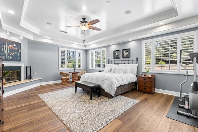 10166 Rancho Roble Rd, Escondido, CA 92026 - bedroom featuring a raised ceiling, ornamental molding, wood-type flooring, recessed lighting, and a glass covered fireplace
