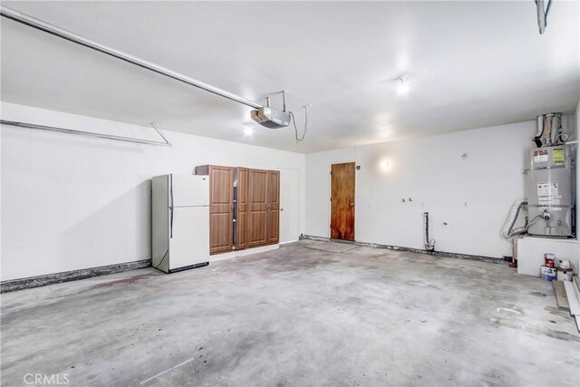 1593 W Carter St, Bloomington, CA 92316 - garage featuring freestanding refrigerator, secured water heater, and a garage door opener