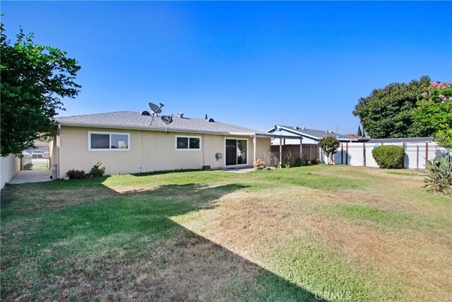 1593 W Carter St, Bloomington, CA 92316 - rear view of house with a fenced backyard and stucco siding