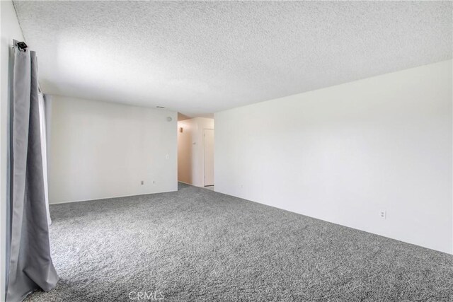 1593 W Carter St, Bloomington, CA 92316 - carpeted empty room with a textured ceiling