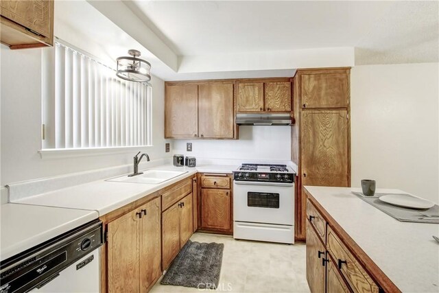 1593 W Carter St, Bloomington, CA 92316 - kitchen featuring white appliances, under cabinet range hood, light countertops, and brown cabinetry