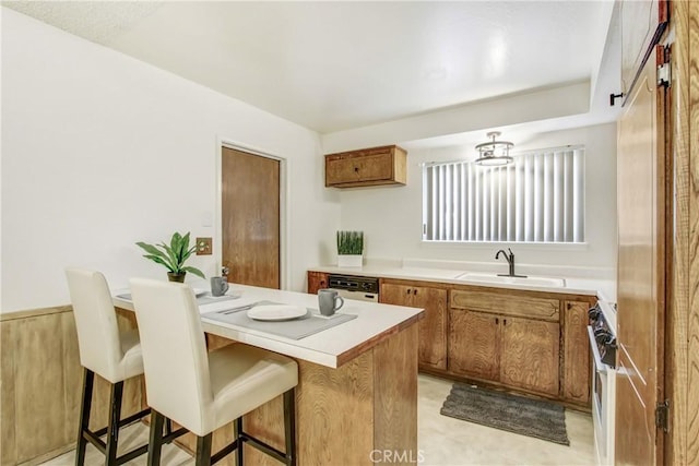 1593 W Carter St, Bloomington, CA 92316 - kitchen featuring white appliances, brown cabinetry, a breakfast bar area, and light countertops