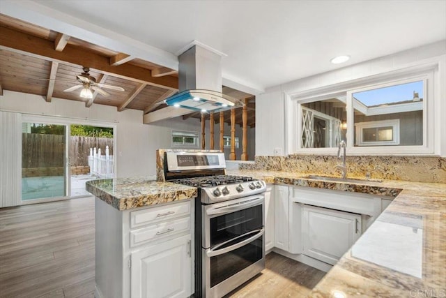 8123 Palm St, Lemon Grove, CA 91945 - kitchen with range with two ovens, island range hood, light wood finished floors, white cabinetry, and wood ceiling