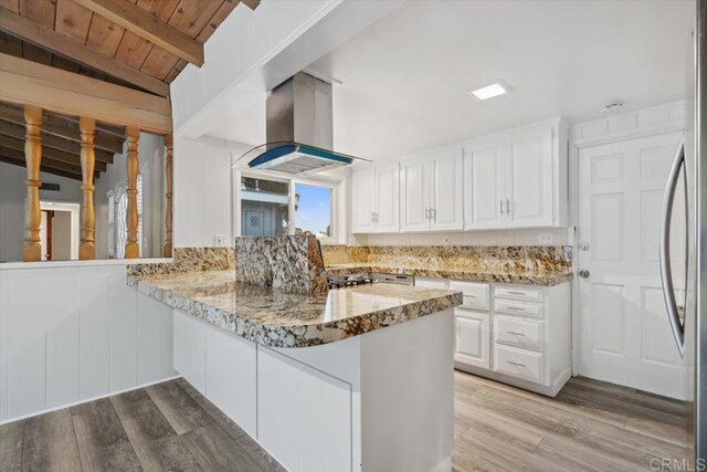 8123 Palm St, Lemon Grove, CA 91945 - kitchen with island exhaust hood, white cabinetry, a peninsula, light wood-type flooring, and wooden ceiling
