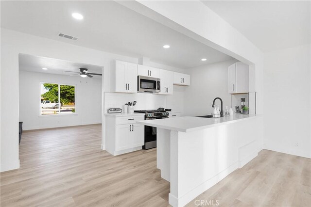 9546 San Pablo Ave, Hesperia, CA 92345 - kitchen with appliances with stainless steel finishes, light wood finished floors, light countertops, recessed lighting, and a peninsula