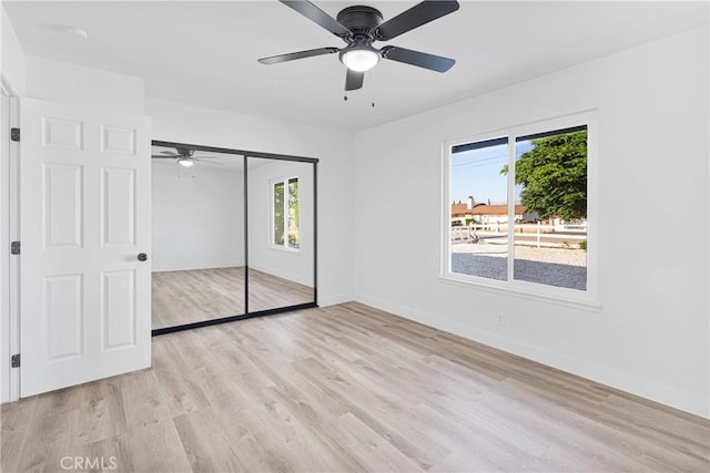 9546 San Pablo Ave, Hesperia, CA 92345 - unfurnished bedroom featuring multiple windows, light wood finished floors, a closet, and a ceiling fan
